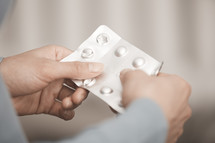 Hands of woman holding pack of medication 