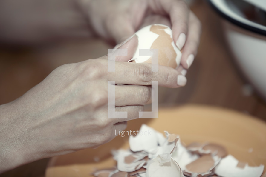 a woman peeling a hardboiled egg 