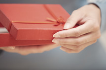 woman opening a red gift box 