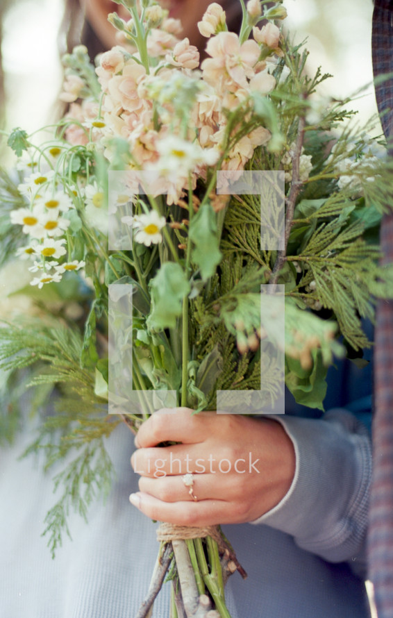 engaged woman holding a bouquet of flowers 