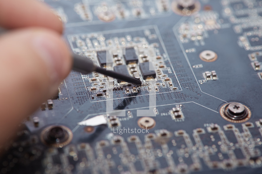 hand repairing a motherboard 