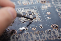 hand repairing a motherboard 