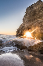 sunburst through a cave on a beach 
