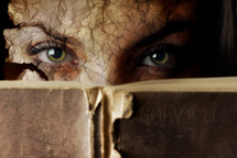 Conceptual photo of old Bible and cracked face