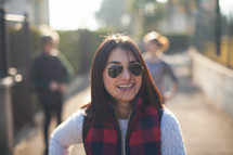 face of a woman in sunglasses standing outdoors in bright sunlight 