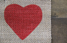 red heart on burlap on wooden background 