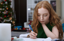 girl doing homework at Christmas 