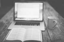 computer screen, open Bible, and coffee mug