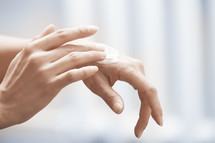 a woman putting lotion on her hands 