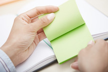 a woman holding a pad of sticky notes 