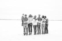 family and friends standing outdoors in the snow 