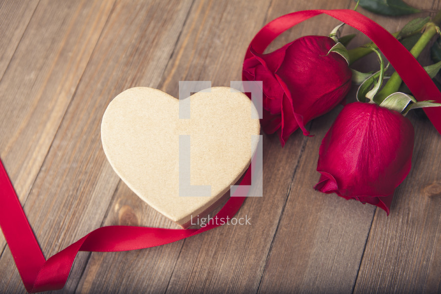 heart shaped gift box, red ribbon, and red roses 
