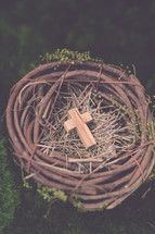 A wooden cross in a bird's nest