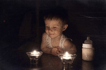toddler watching candle flames 