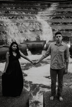 a couple holding hands on a fountain 