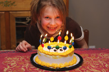 a young girl with the joy of her birthday cake and candles