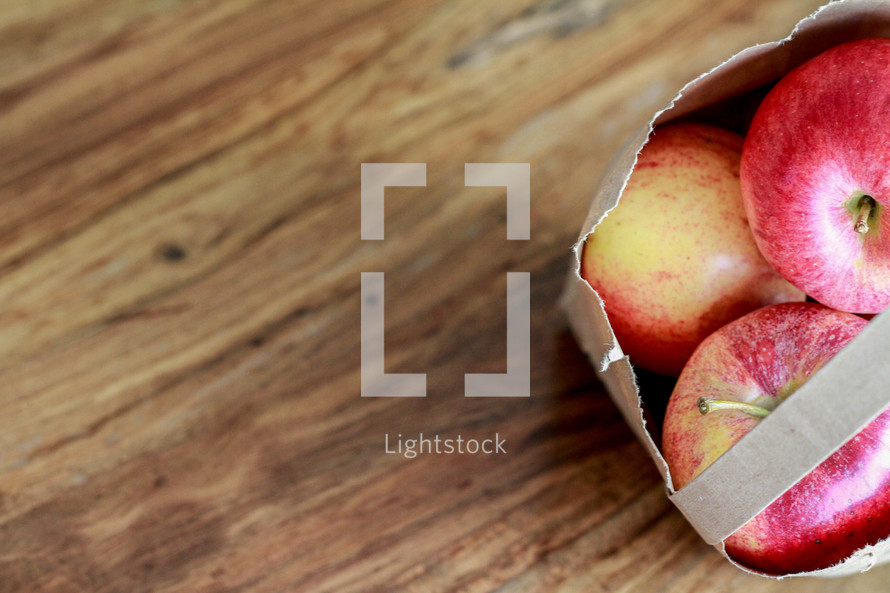 bag of apples on a wood background 