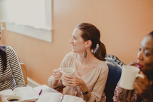 women drinking coffee and reading Bibles at a Bible study 