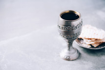 Jewish kiddush wine cup for passover with matzot, matzo bread. Pesah holiday. Banner with copy space. Christian communion concept for reminder of Jesus sacrifice. Easter passover