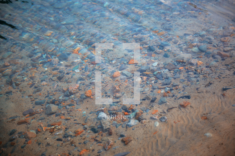 stones on sand in shallow water 