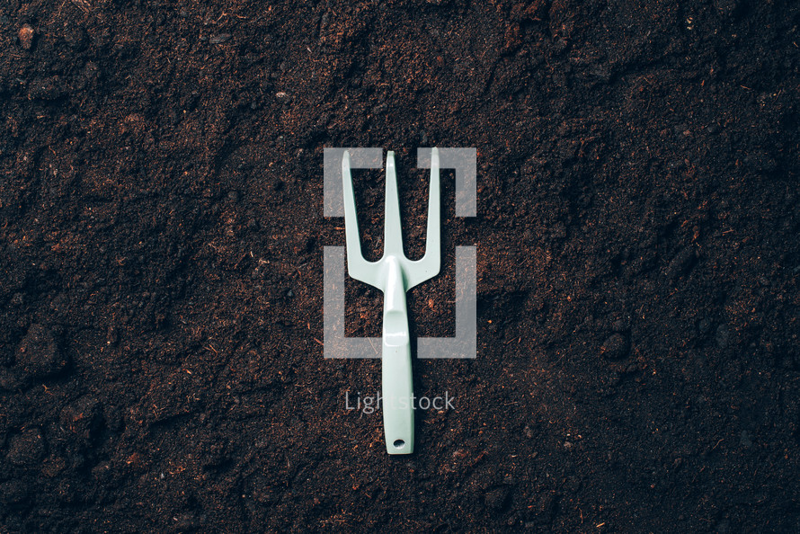 Gardening tools and utensils on soil background. Top view with copy space. Pruner, rake, shovel for garden manteinance. Summer season. Farming, landscaping concept
