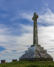 Memorial cross in the church yard of the site containing the Kirkmadrine Stones in Dumfries and Galloway, Scotland, UK set against a blue sky with white clouds