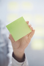 woman holding a pad of sticky notes 