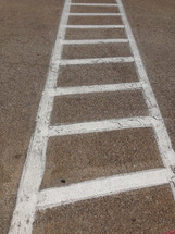 white lines delineate a crosswalk, ladder-like effect