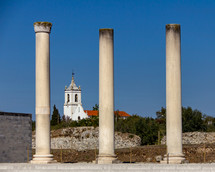 Church framed by Roman Columns at  Conimbriga in Portugal under a cloudless blue sky