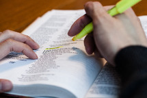 Hands highlighting a passage in The Bible.