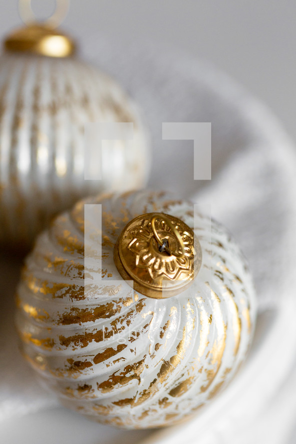 Close Up of Gold and White Christmas Ornaments on a White Background
