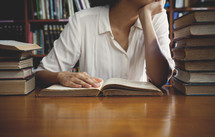 a woman reading a book in a library 