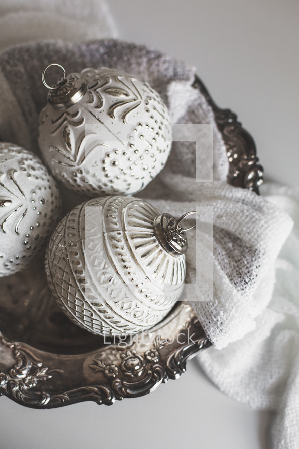 Silver and White Christmas Ornaments in a Silver Bowl on White Background