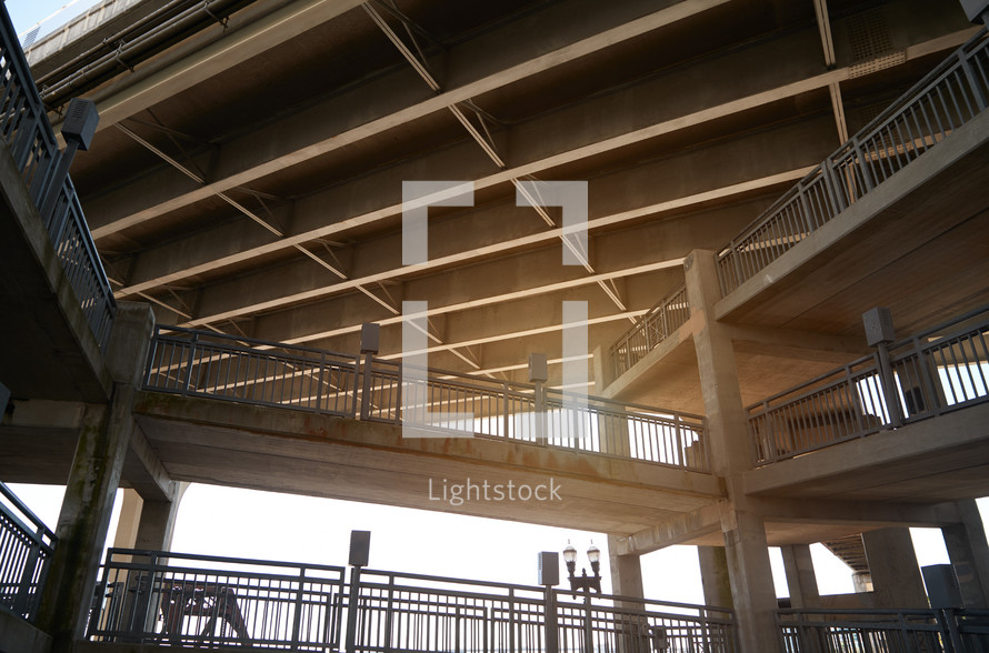 Low angle view of underneath highway bridge and pedestrian footpath