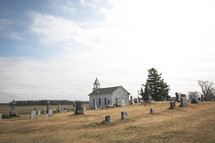 an old church surrounded by a cemetery 
