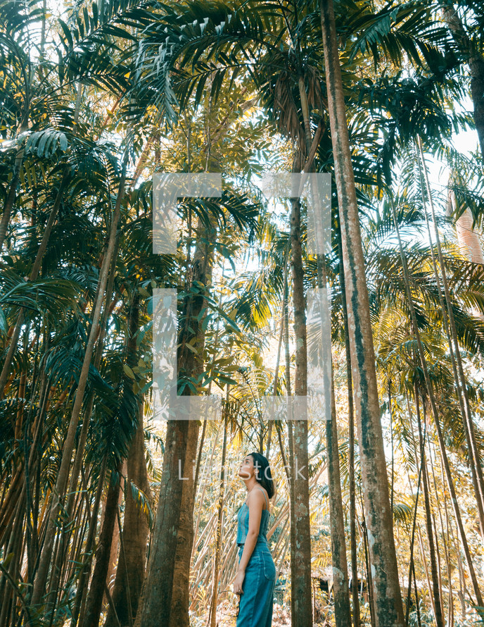a woman standing in a jungle of bamboo 