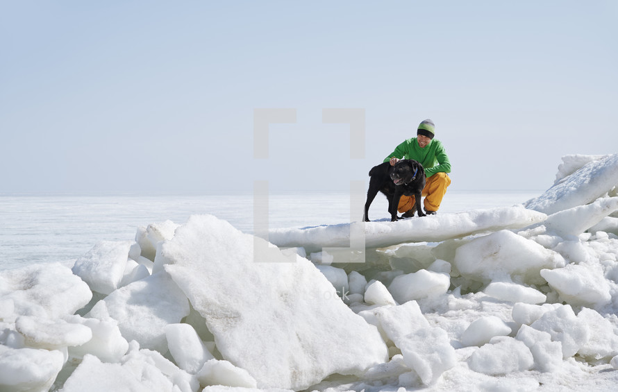 man and his dog hiking through snow 