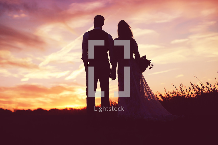 silhouettes of a bride and groom at sunset 