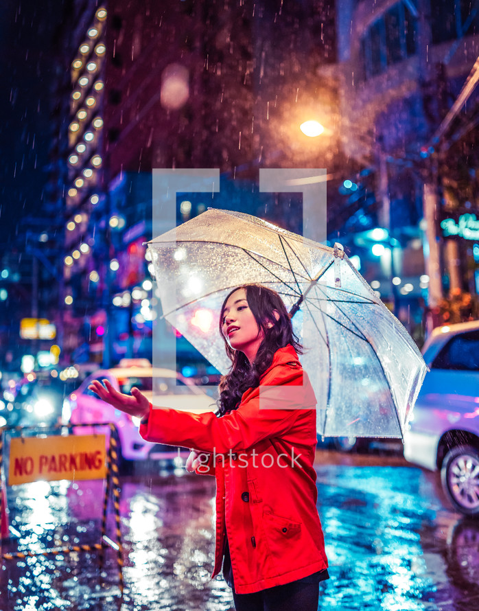 a woman standing in the rain holding an umbrella 