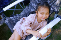 little girl sitting in a folding chair 