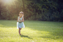 girl running in park with no shoes on grass