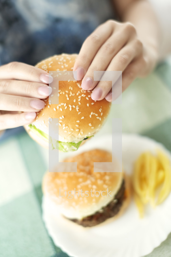 a woman eating a hamburger 