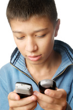 a boy holding two cellphones