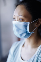 Woman staying at home wearing protective surgical mask