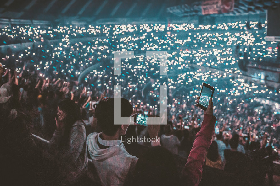 lights from phones in a stadium at a concert 