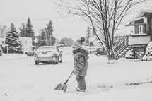a boy shoveling snow 