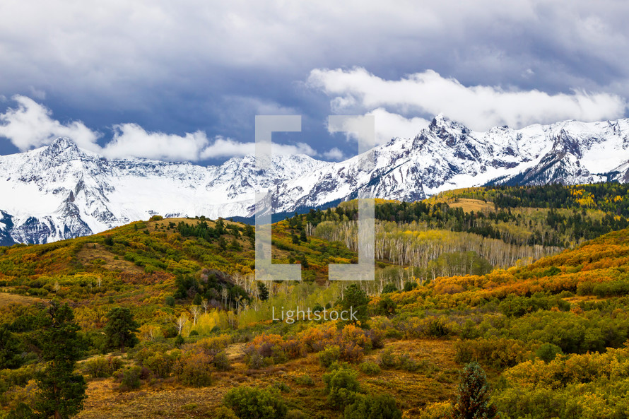 snow capped mountains and fall forest 