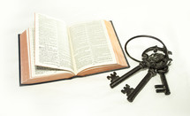 Bible and skeleton keys on a white background 