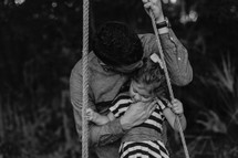 a father and daughter on a rope swing 