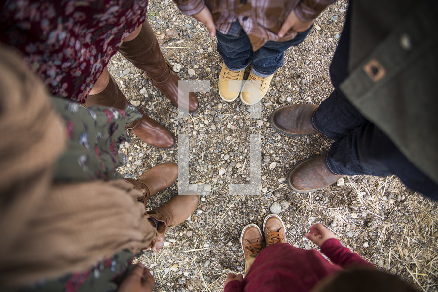 looking down at feet of a family standing in a circle 